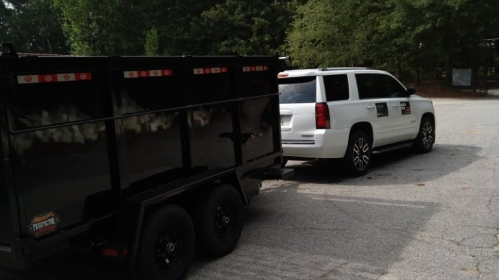 white suburban towing a junk removal trailer leaving for a local jobsite in Atlanta, GA